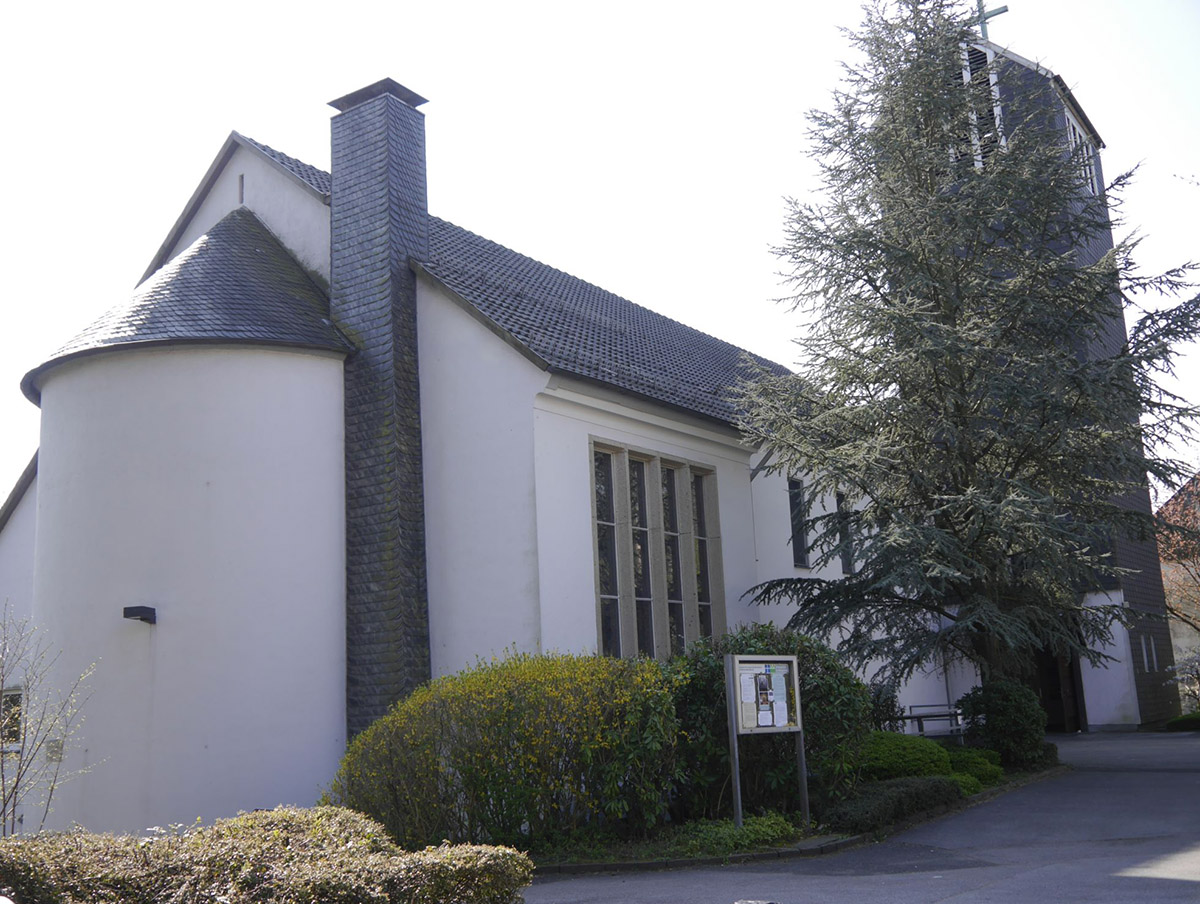 Außenansicht der Auferstehungskirche mit weißer Apsis und seitlichem Glockenturm.